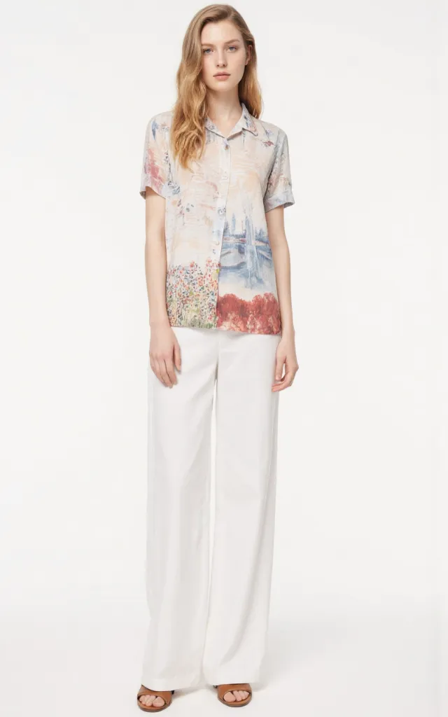 A French female model wearing Resort   style clothing, against a white background, in a front   facing shot focusing on shoes